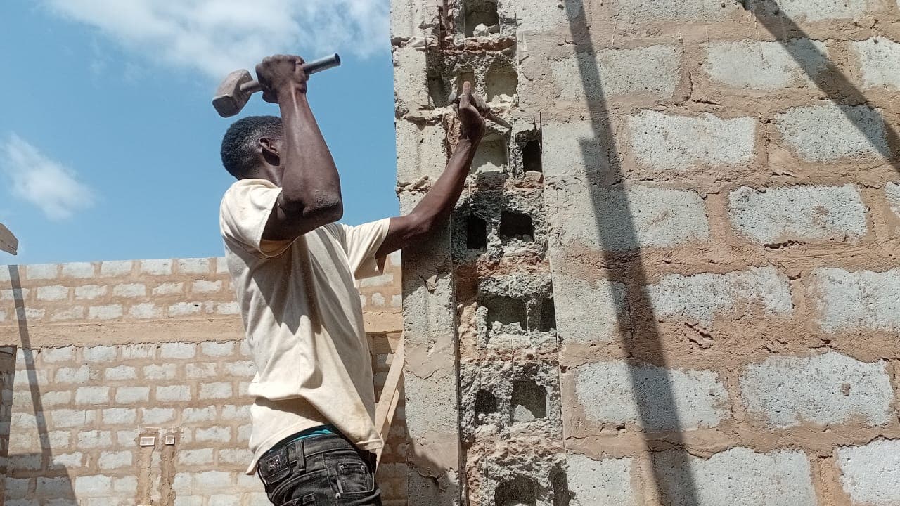 Cables & Pipes technician chasing a concrete block wall to route conduit